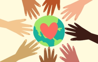 diverse hands in circle reaching for globe with heart on it