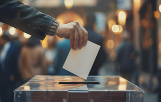 hand putting ballot in vote box