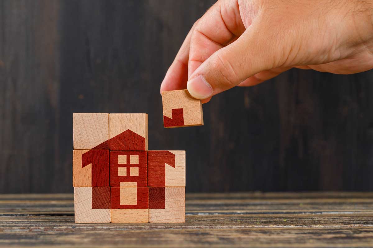 stay-home-concept-wooden-table-side-view-hand-holding-wooden-cube